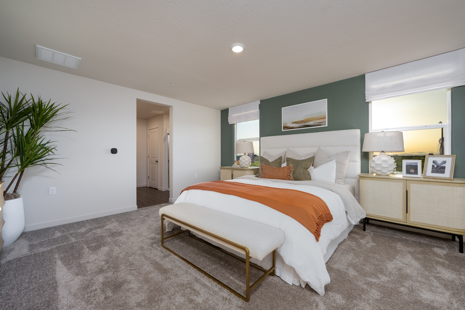 A large bedroom with a bed and a bench.