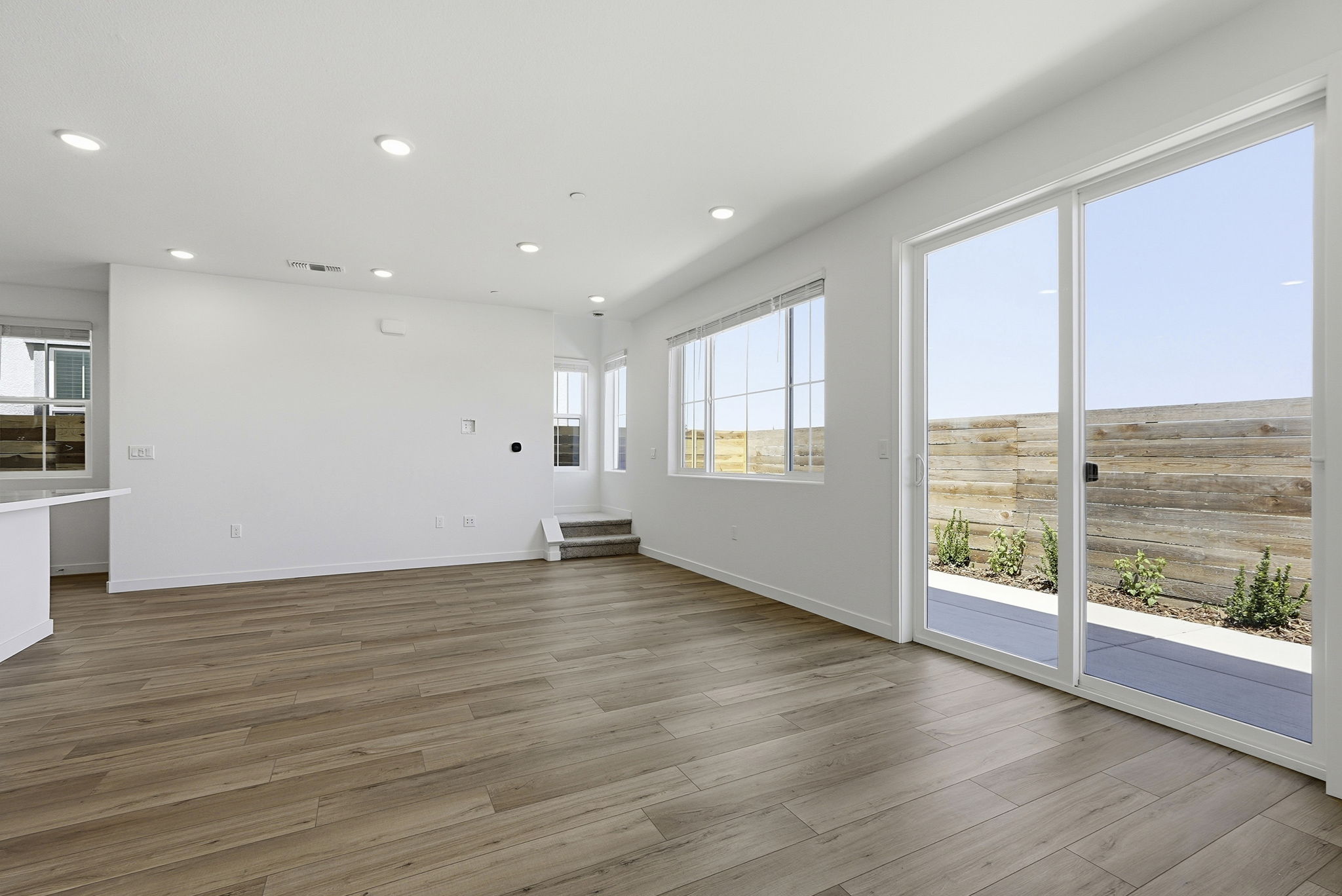 A large room with a wood floor and large windows.