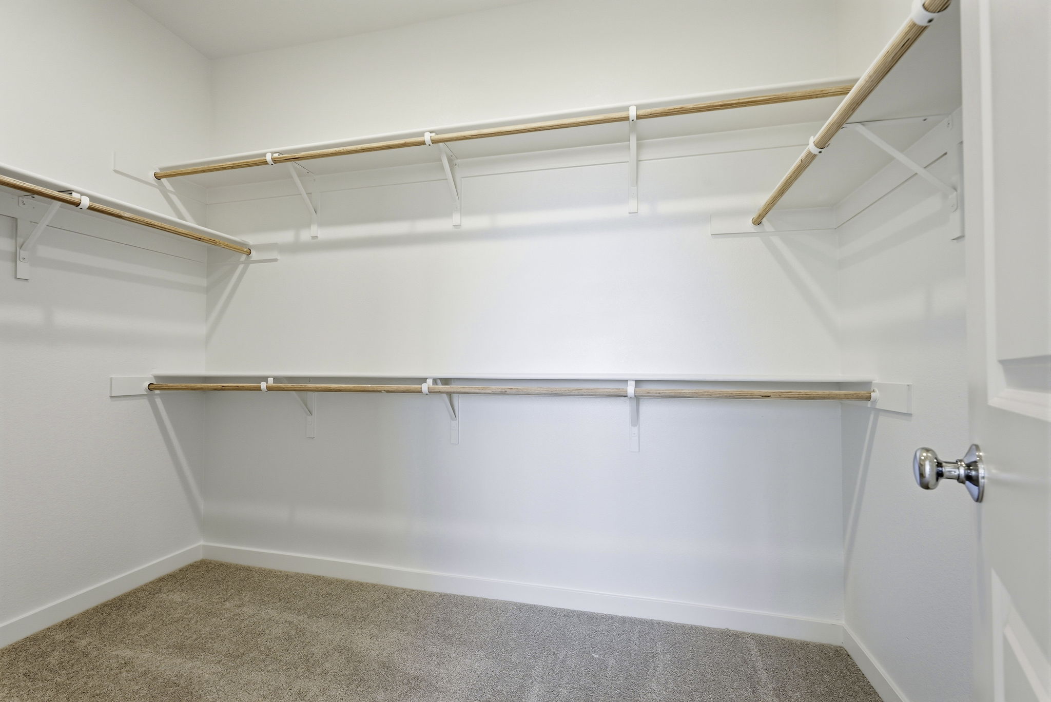 A white wall with a metal bar.