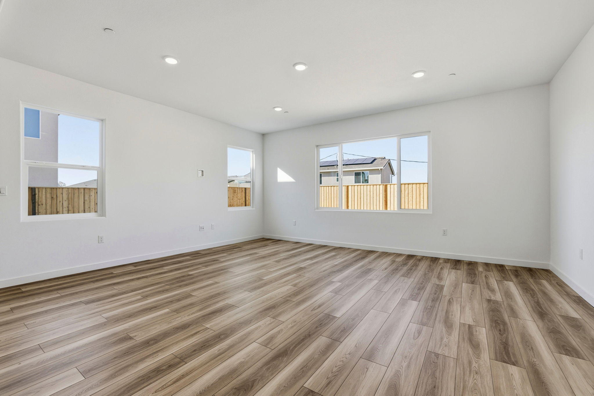 A room with a wood floor and a wood floor with a window.