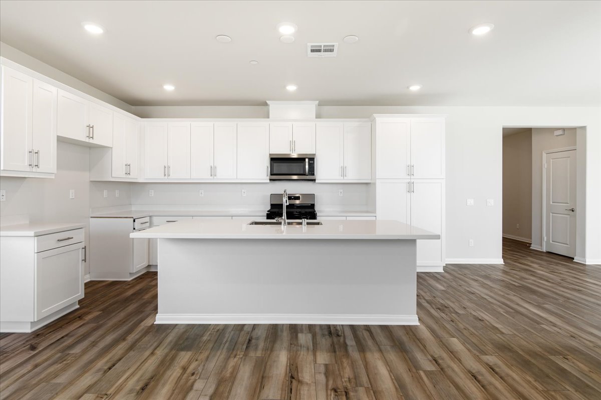A kitchen with white cabinets.