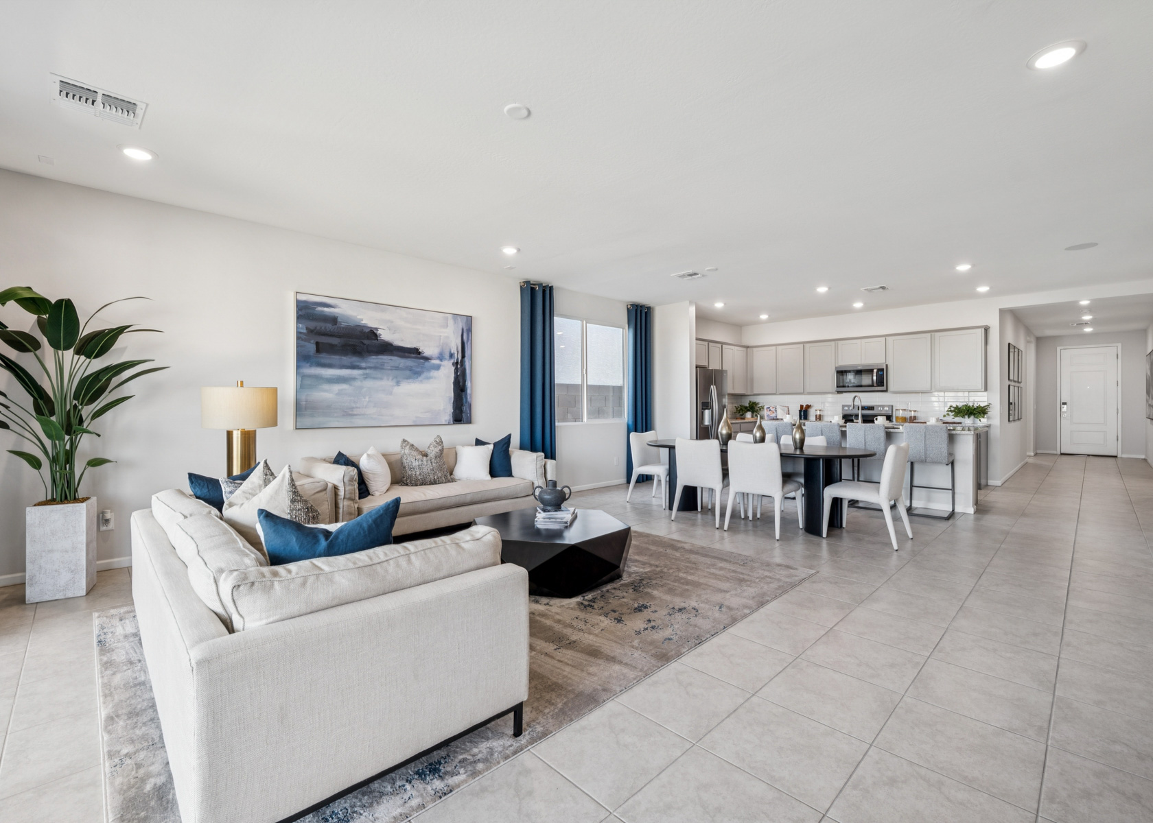 A living room with a white couch and a dining table.