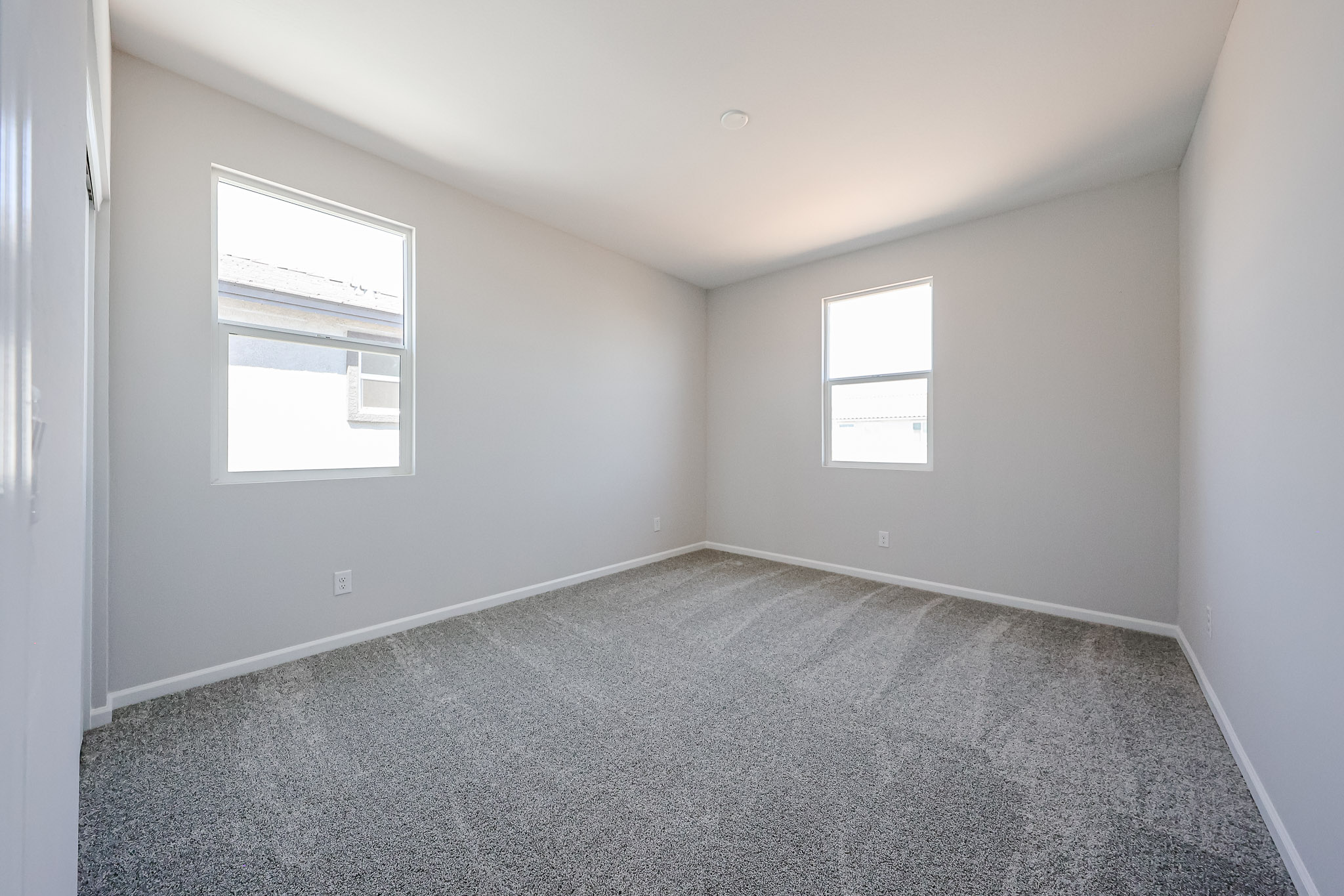 A room with a carpet and windows.