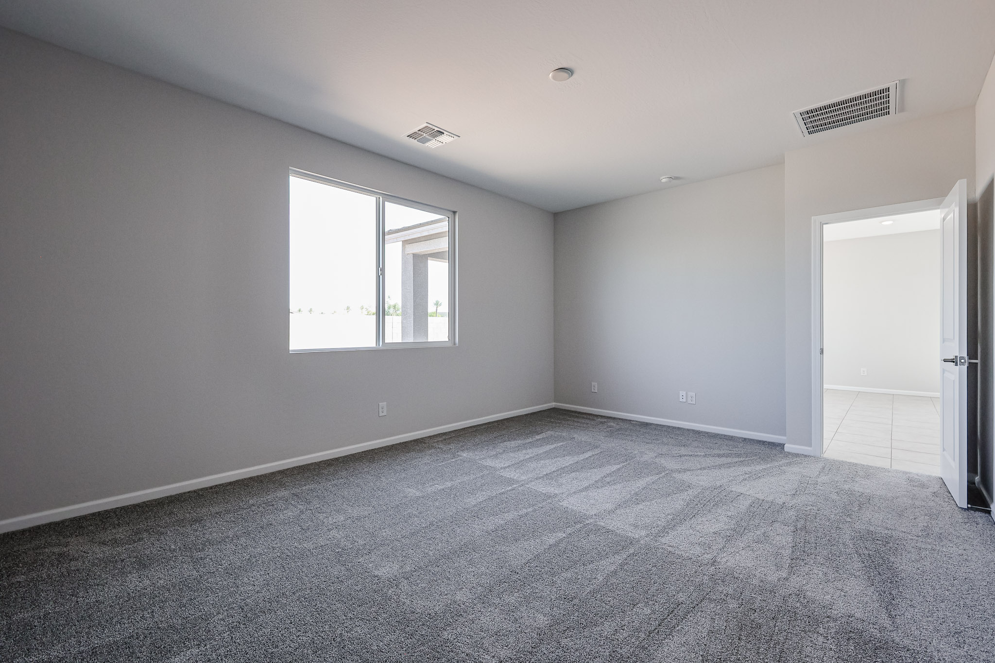 A room with a carpet and a window.