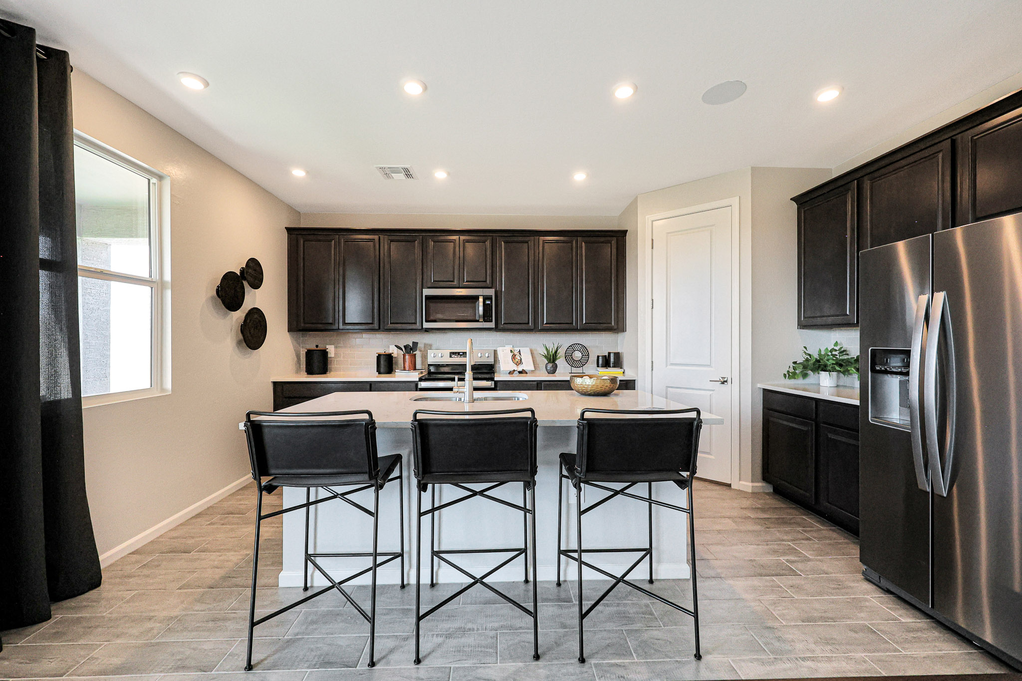 A kitchen with black chairs.