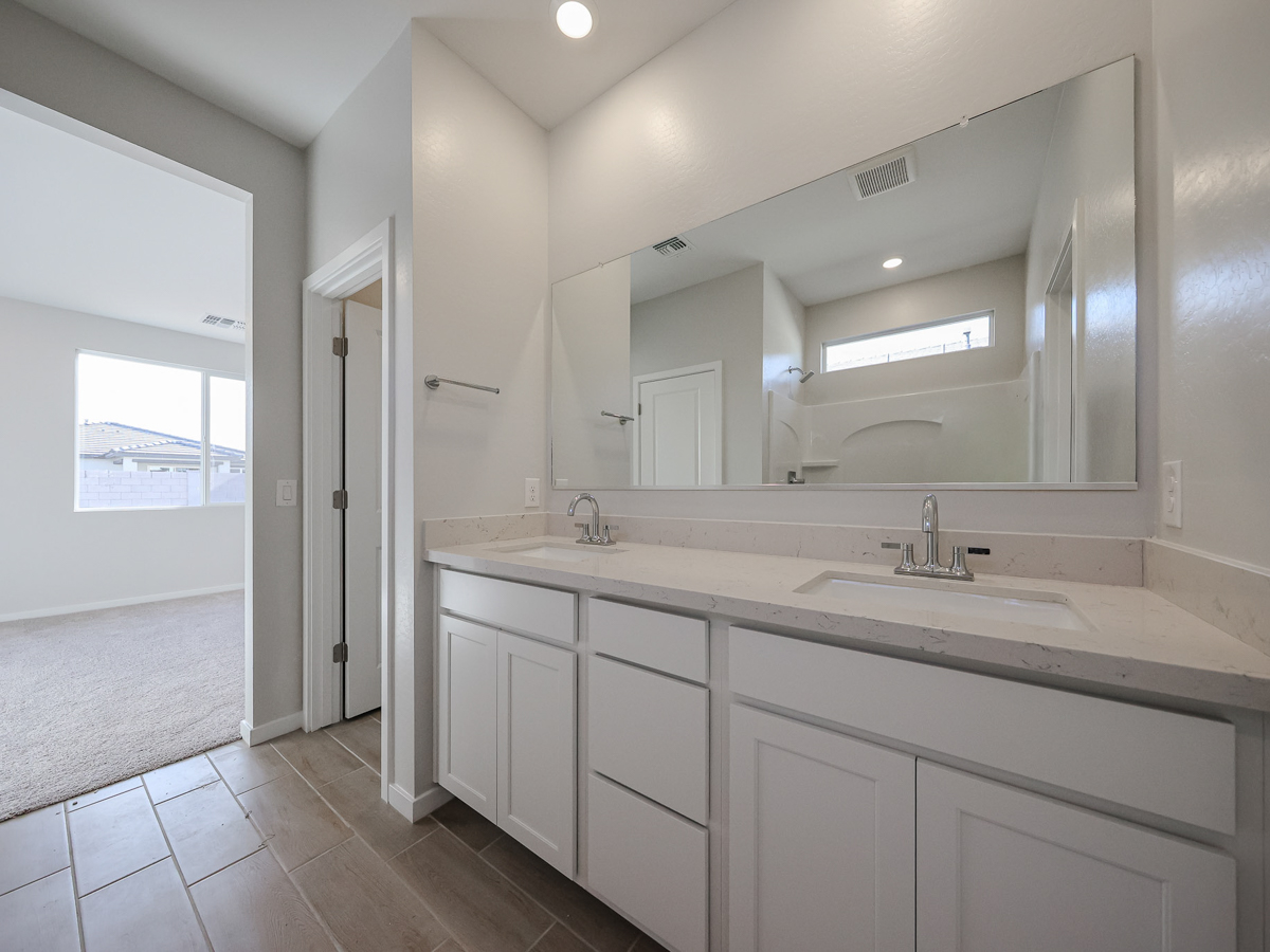 A bathroom with white cabinets.