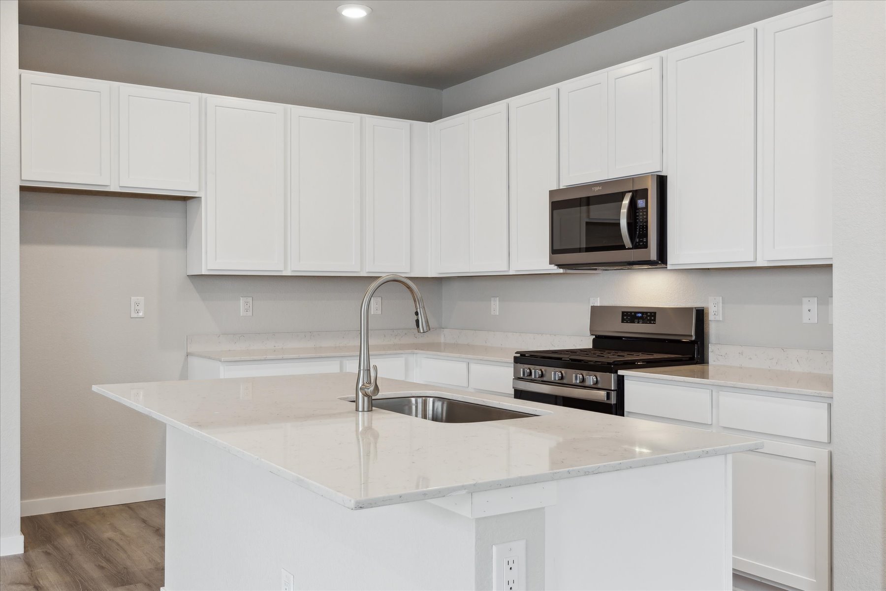 A kitchen with white cabinets.