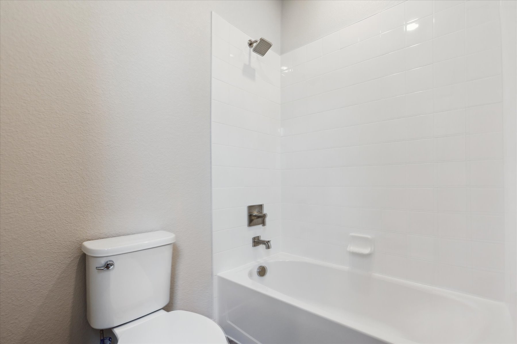 A bathroom with a toilet and bathtub.
