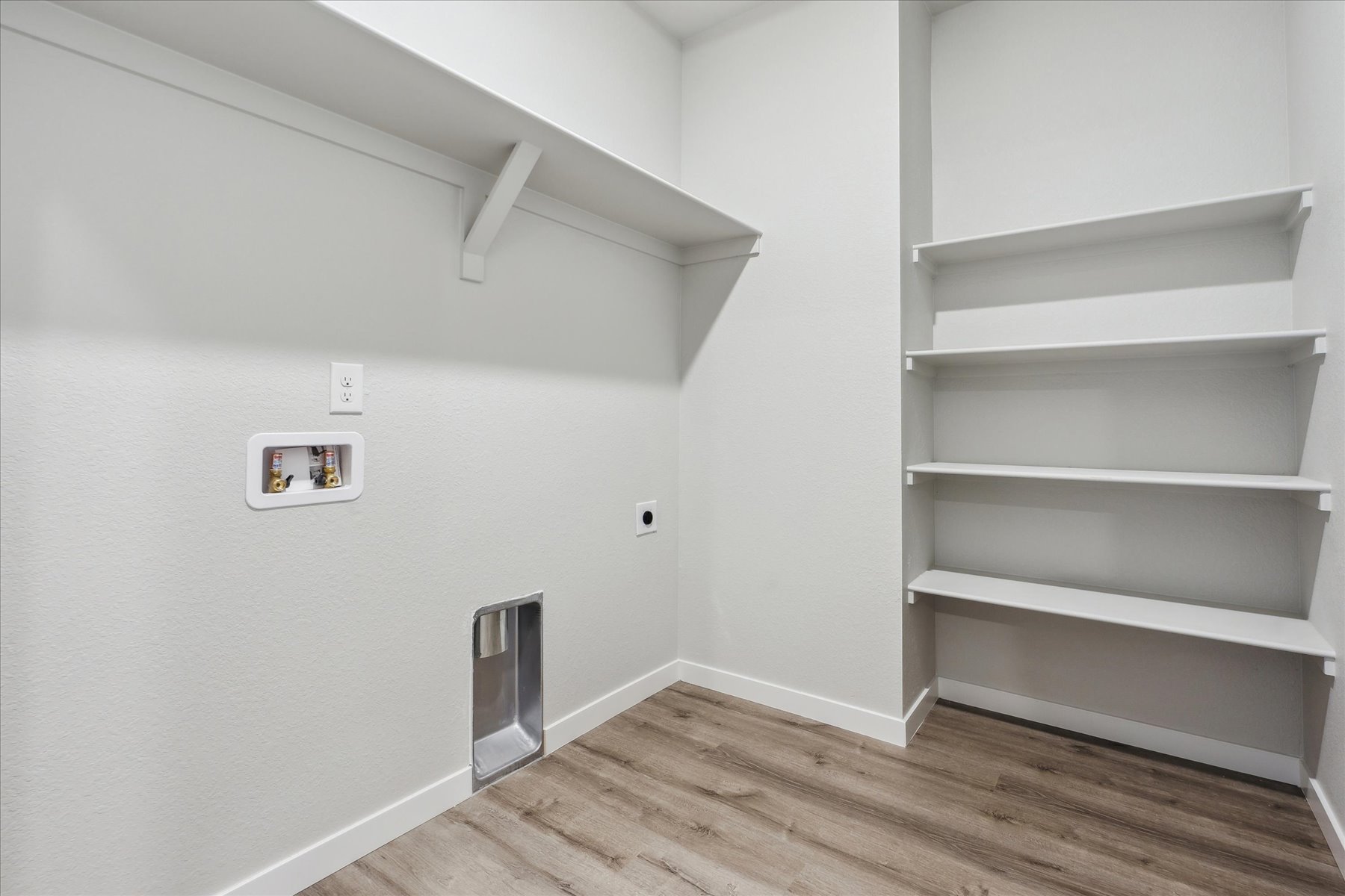 A white room with a shelf and a white wall.