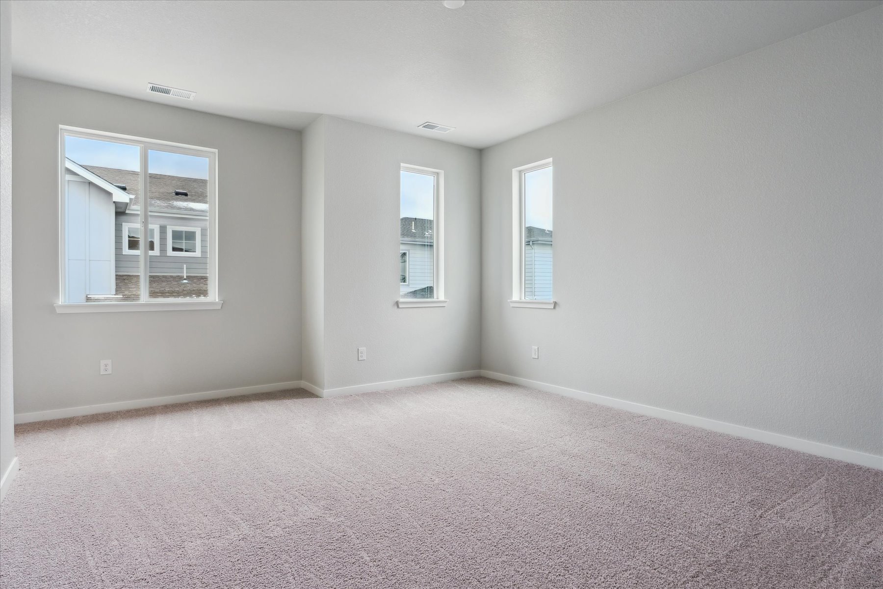 A room with a carpet and windows.