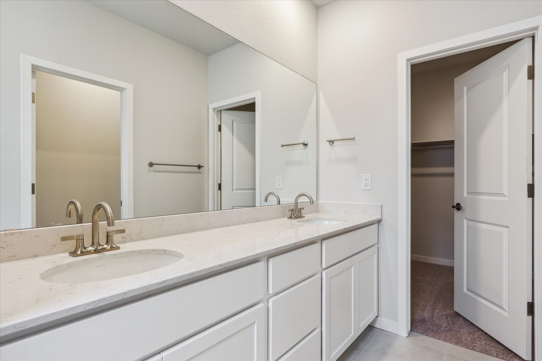 A bathroom with white cabinets.