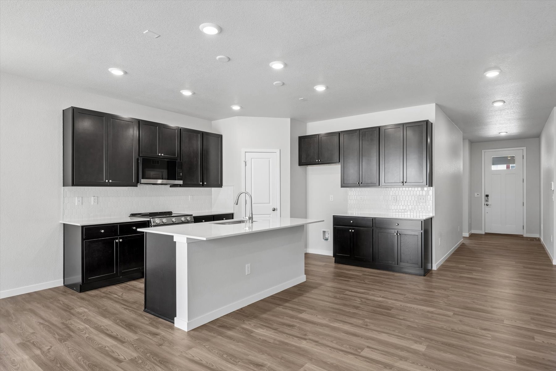 A kitchen with black cabinets.