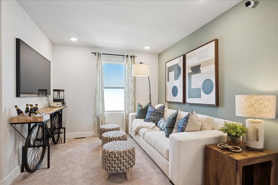 A living room with a white couch and a white table.
