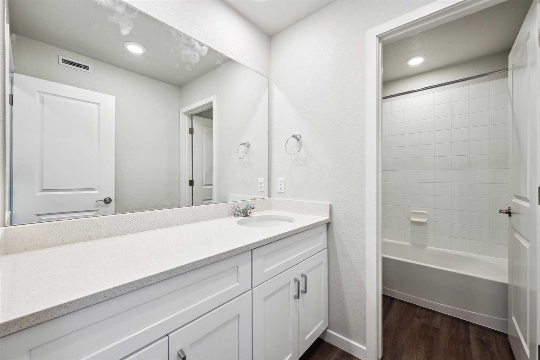 A bathroom with a large mirror.