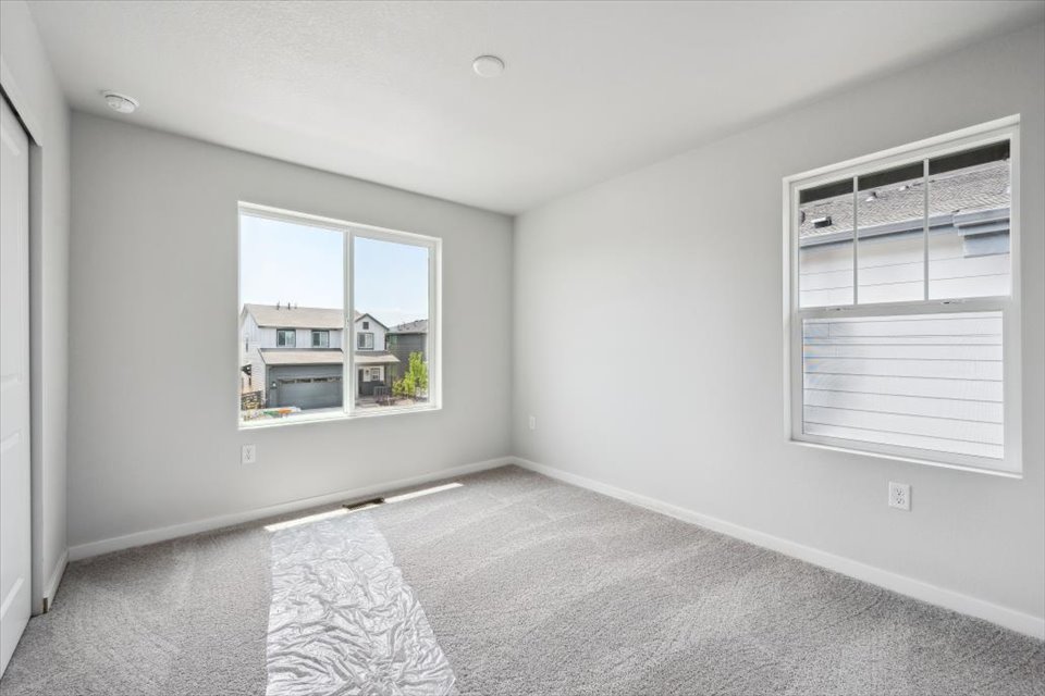 A room with a window and a rug.