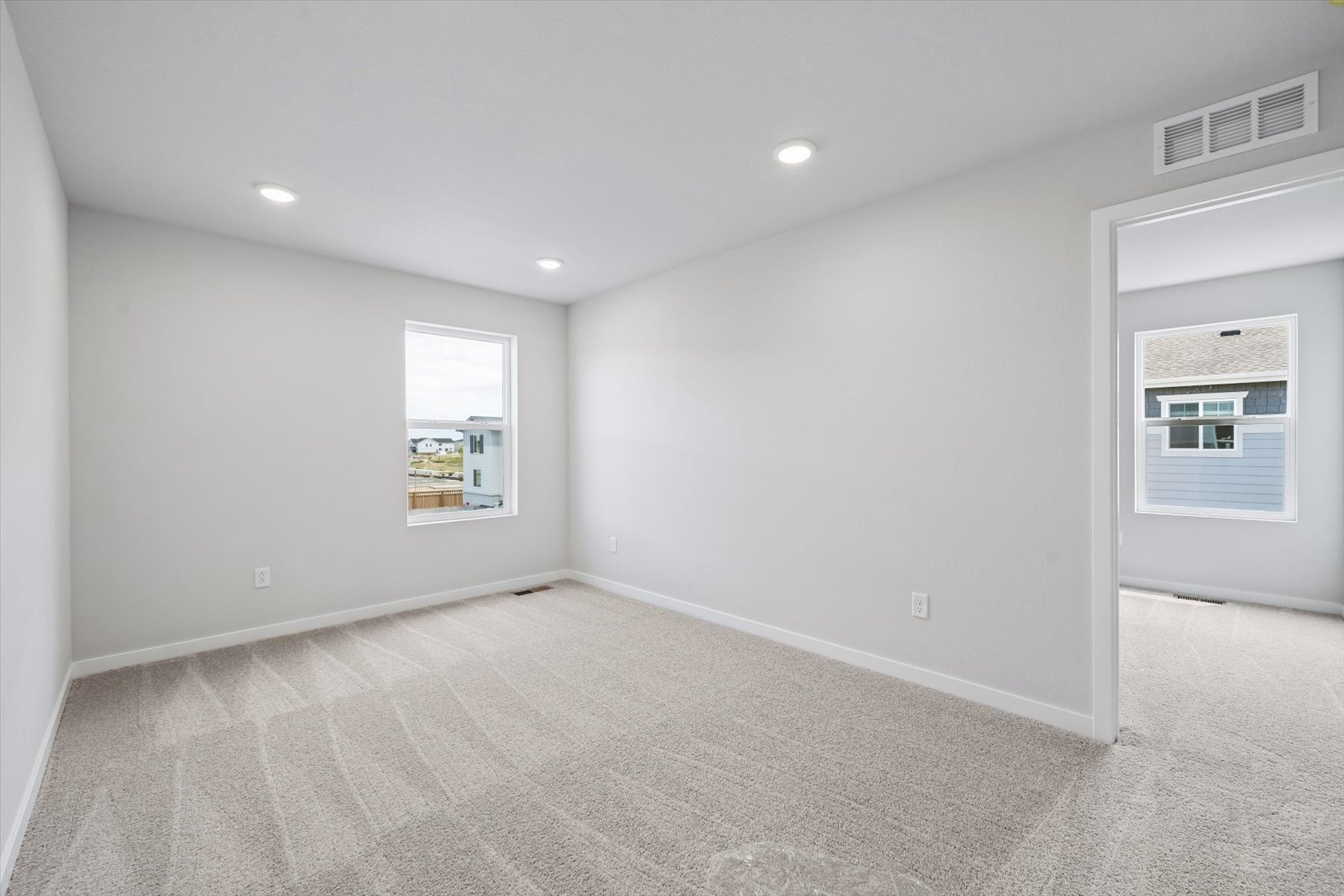 A room with a white wall and a window.