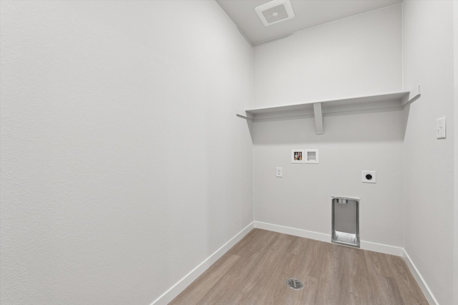 A room with a wood floor and white walls.