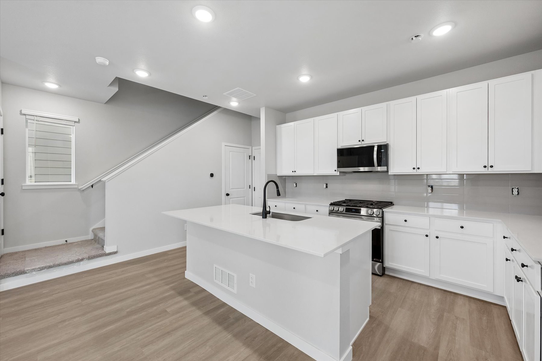 A kitchen with white cabinets.