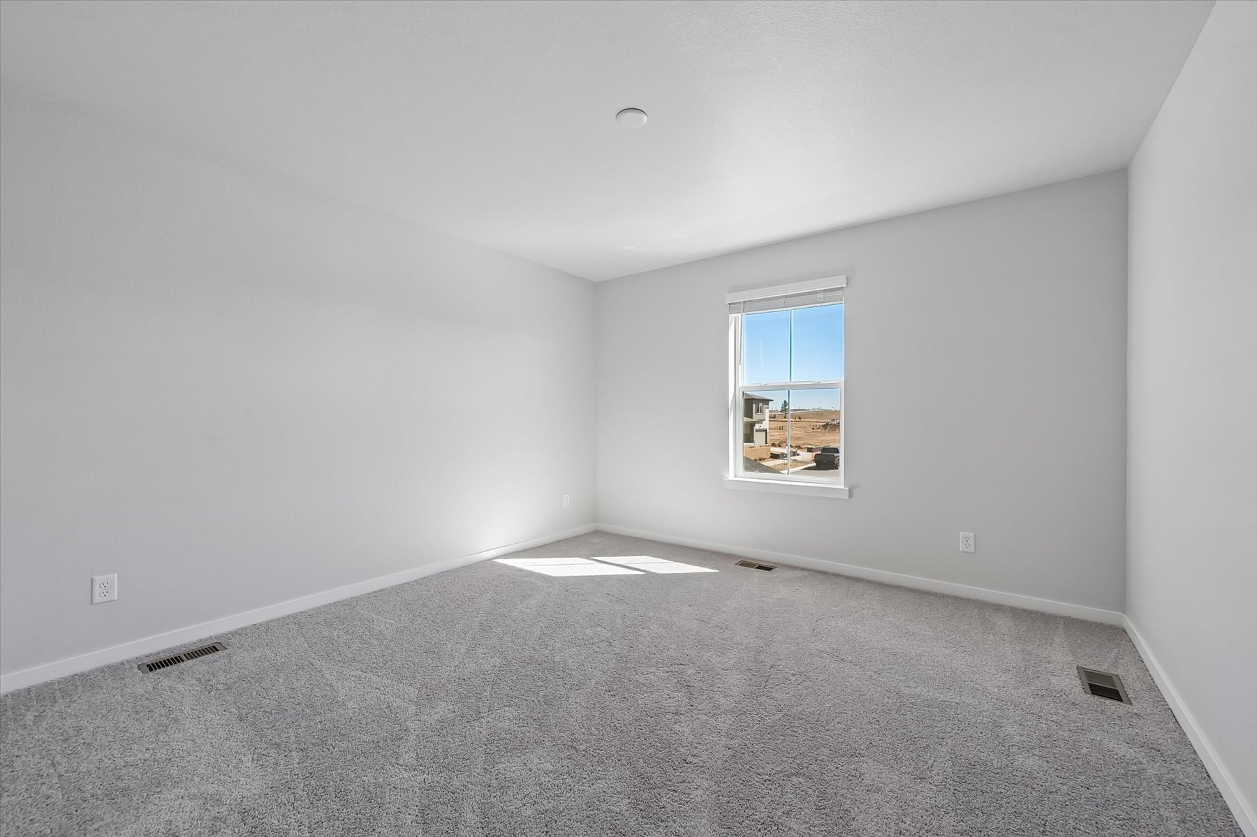 A room with a window and a carpet.
