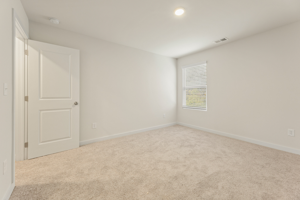 A room with white walls and a carpeted floor.