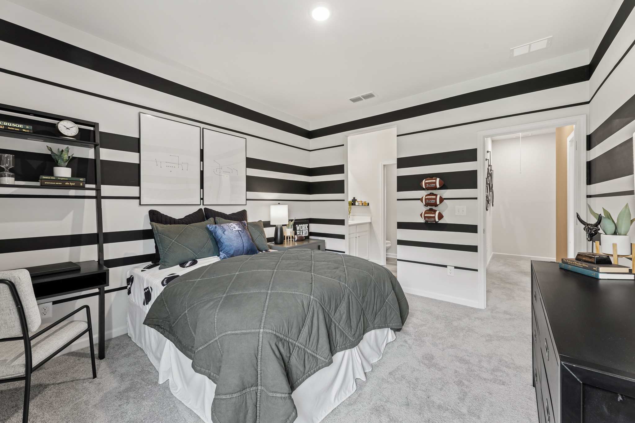 A bedroom with a bed and a desk.