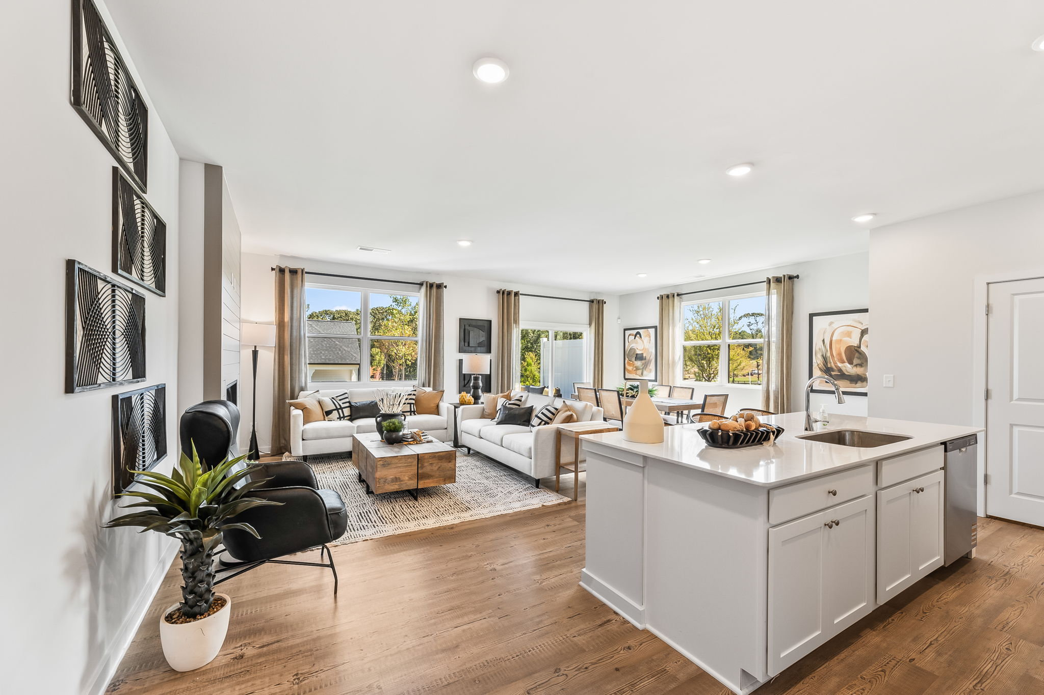 A large living room with a large kitchen and a large window.
