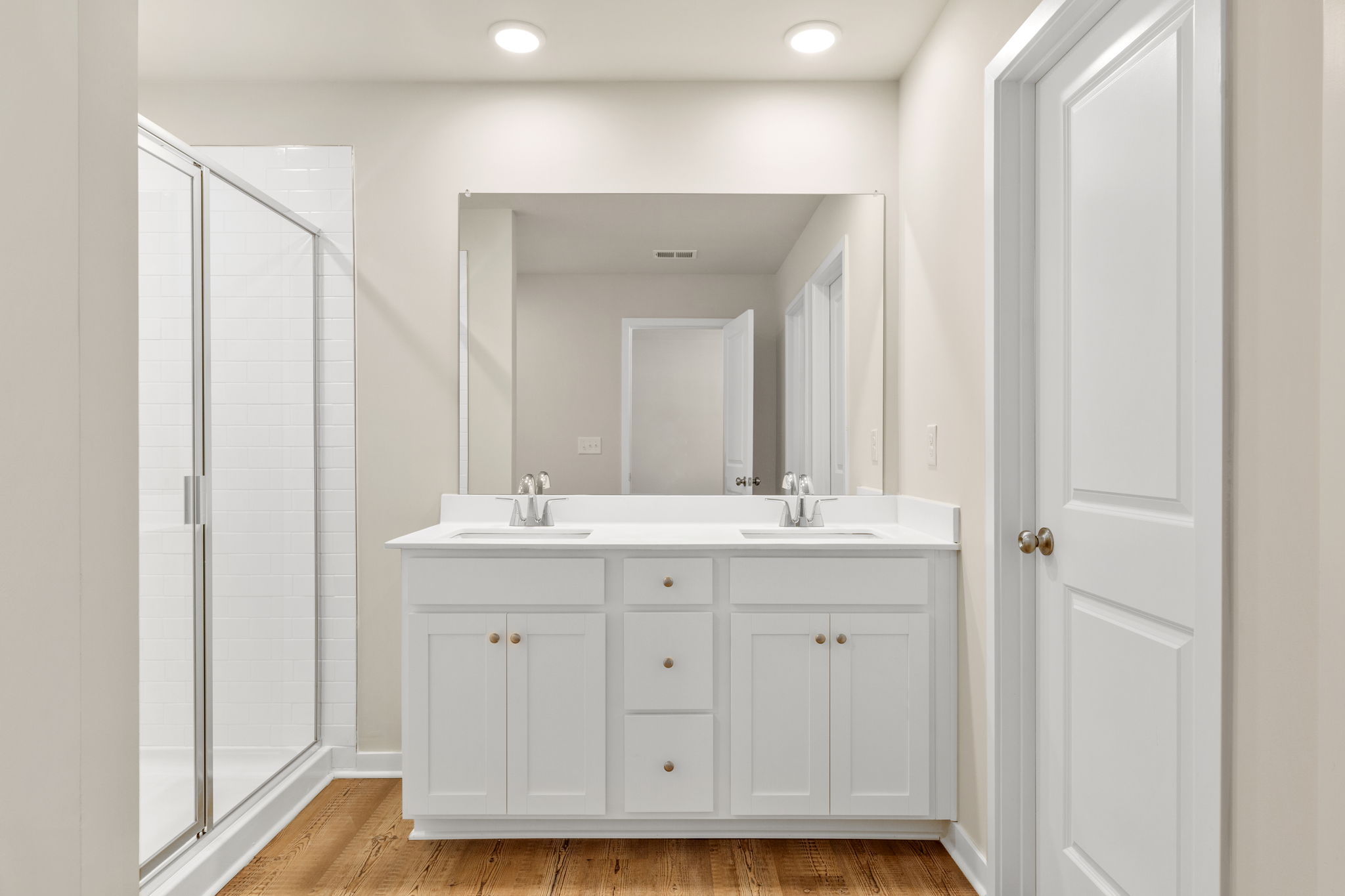 A bathroom with white cabinets.