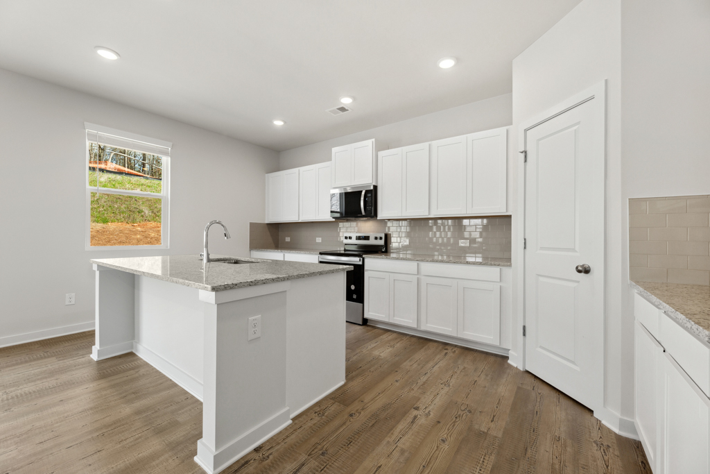 A kitchen with white cabinets.