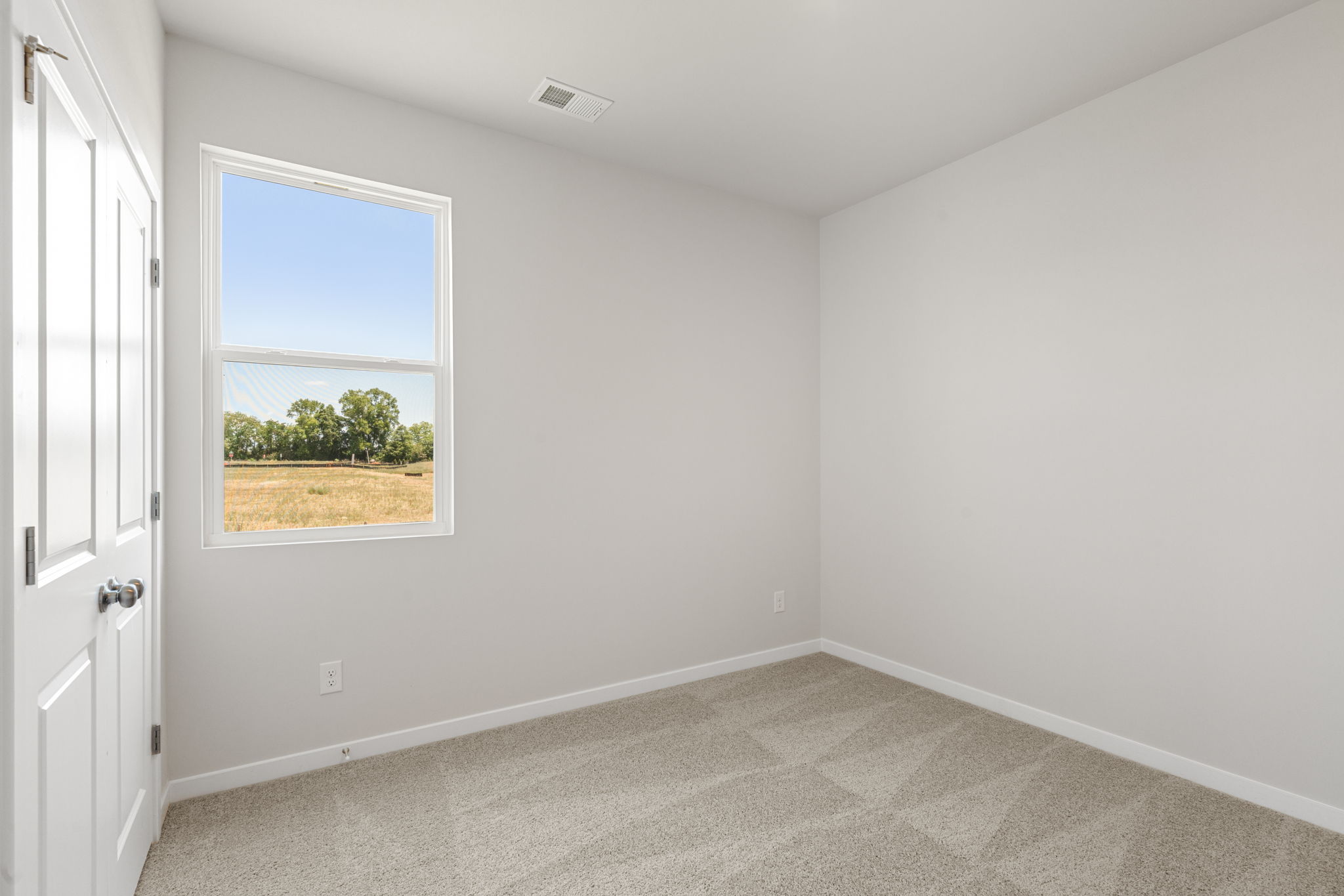 A room with a window and a carpet.