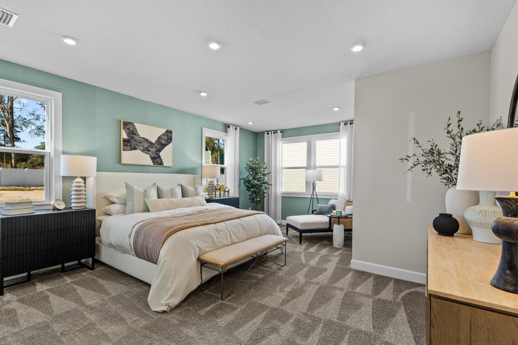 A bedroom with a bed and a bench.