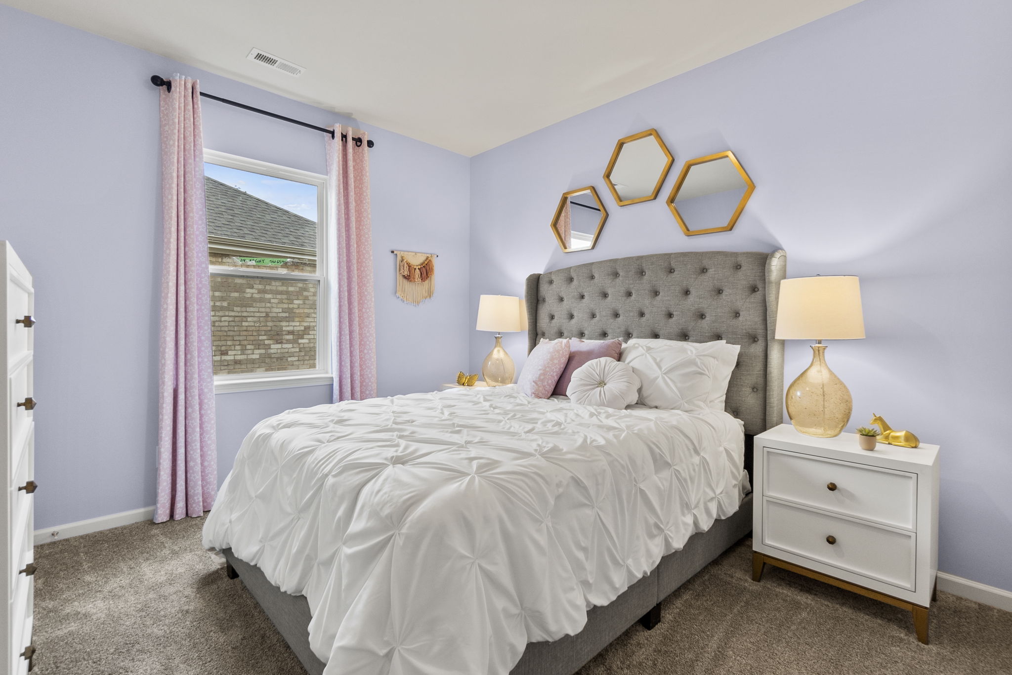 A bedroom with a bed and lamps.