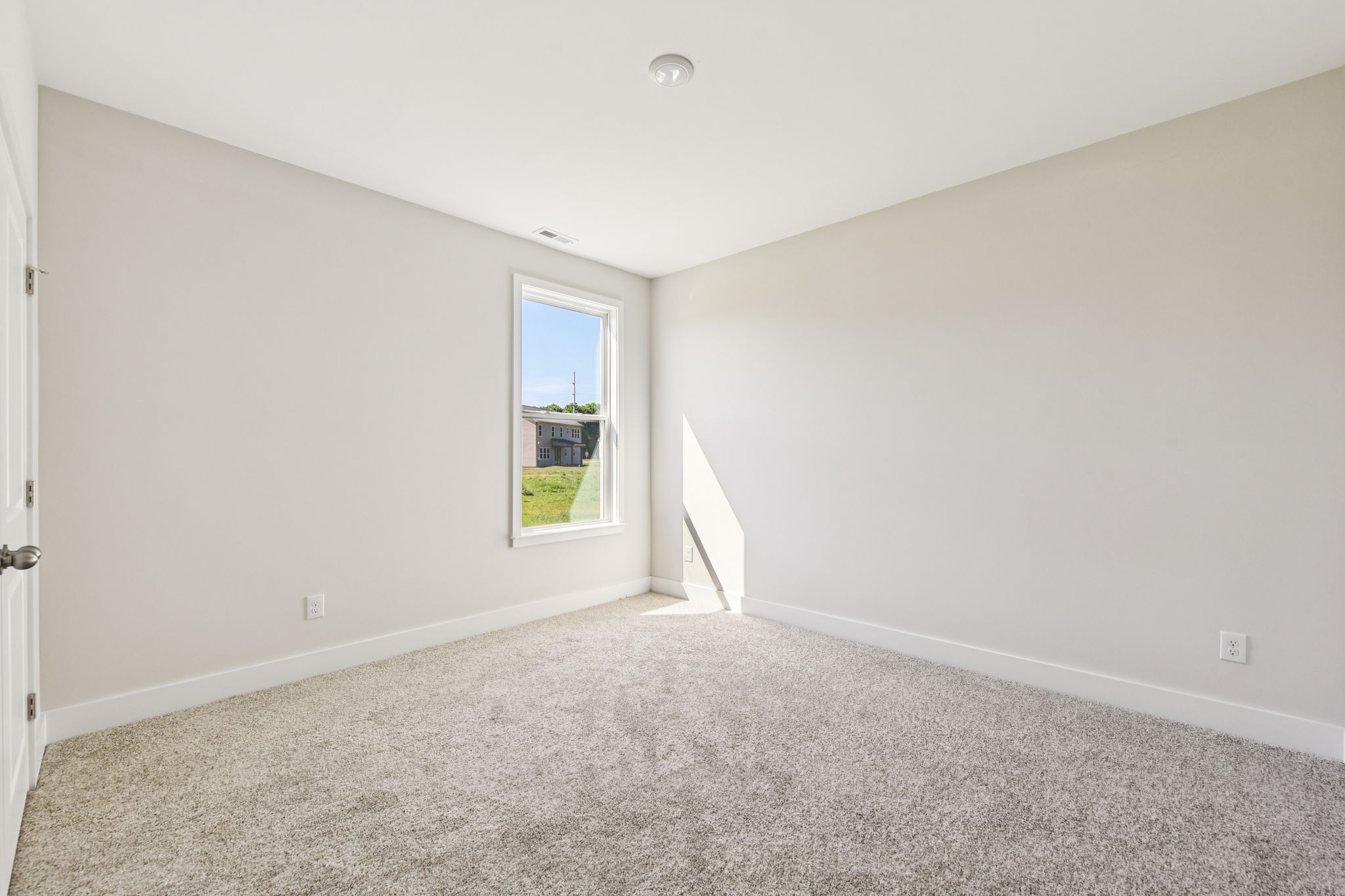 A room with a carpet and a window.