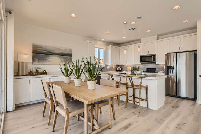 A kitchen with a dining table and chairs.
