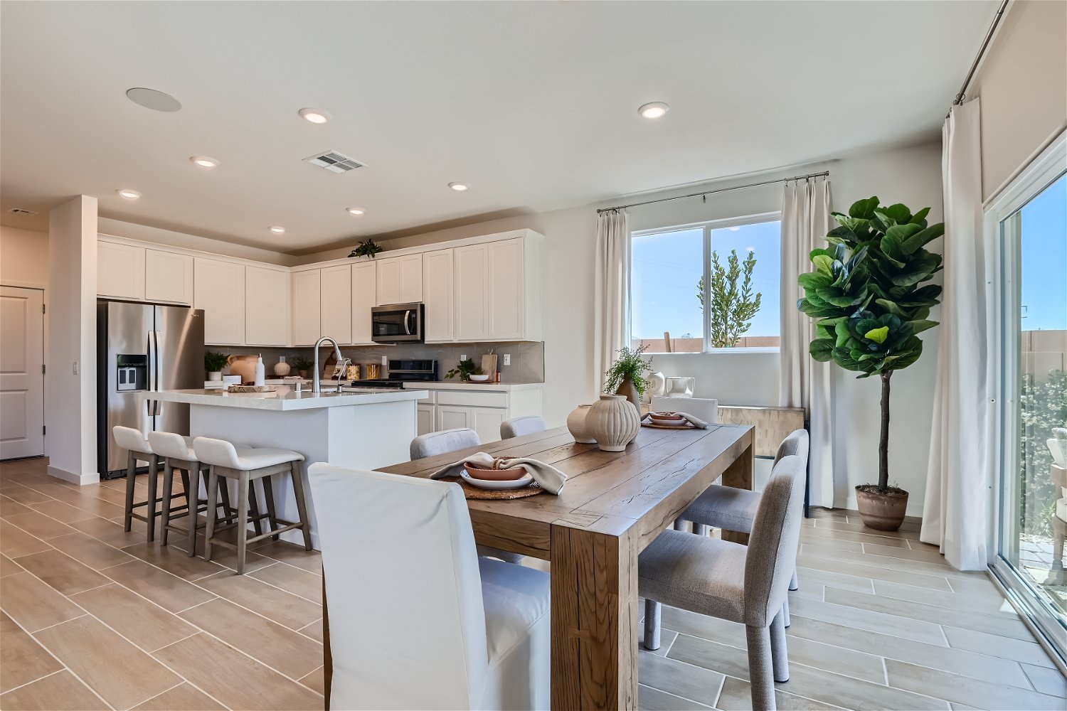 A kitchen with a dining table and chairs.