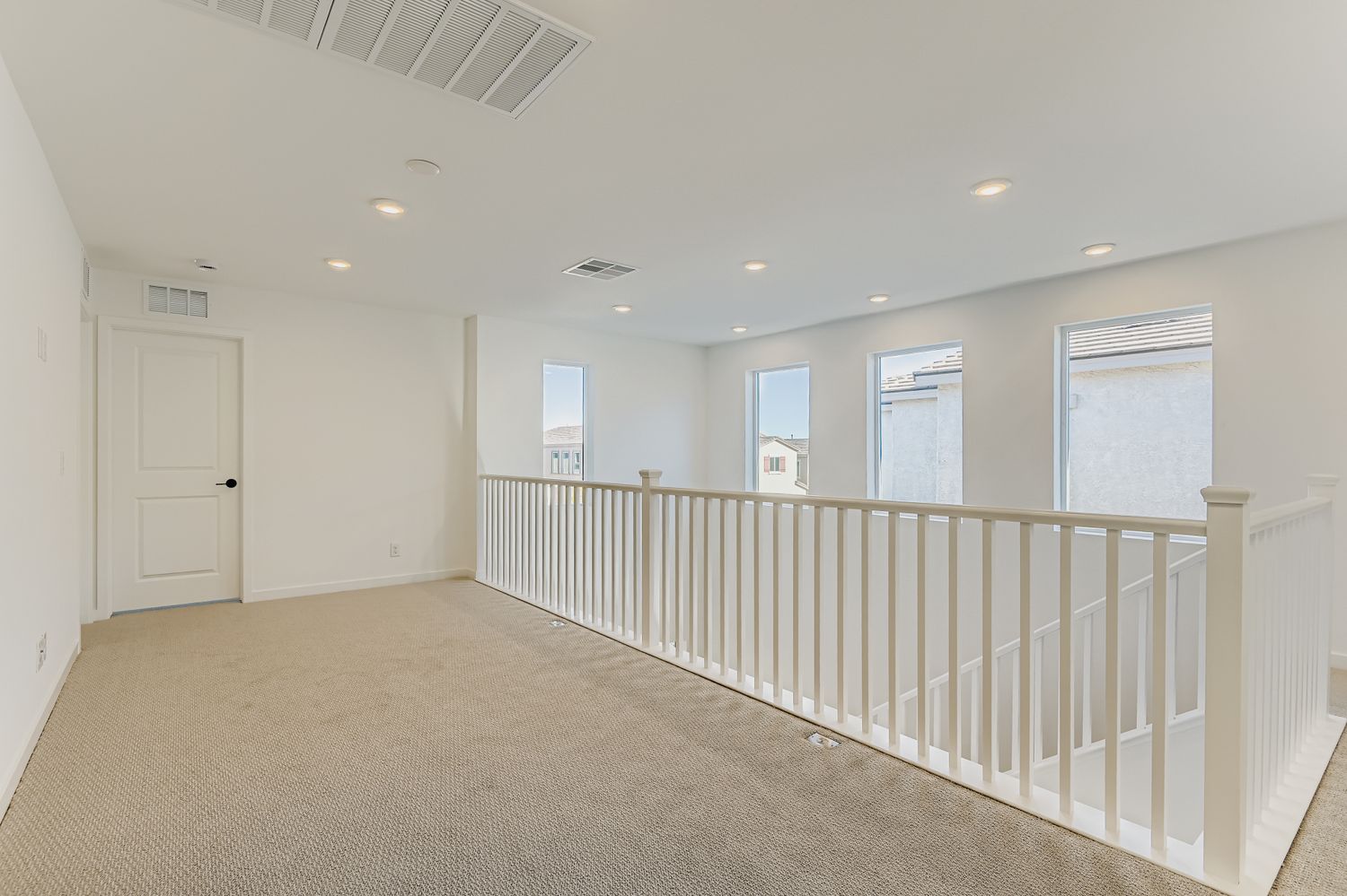 A long white hallway with white doors.
