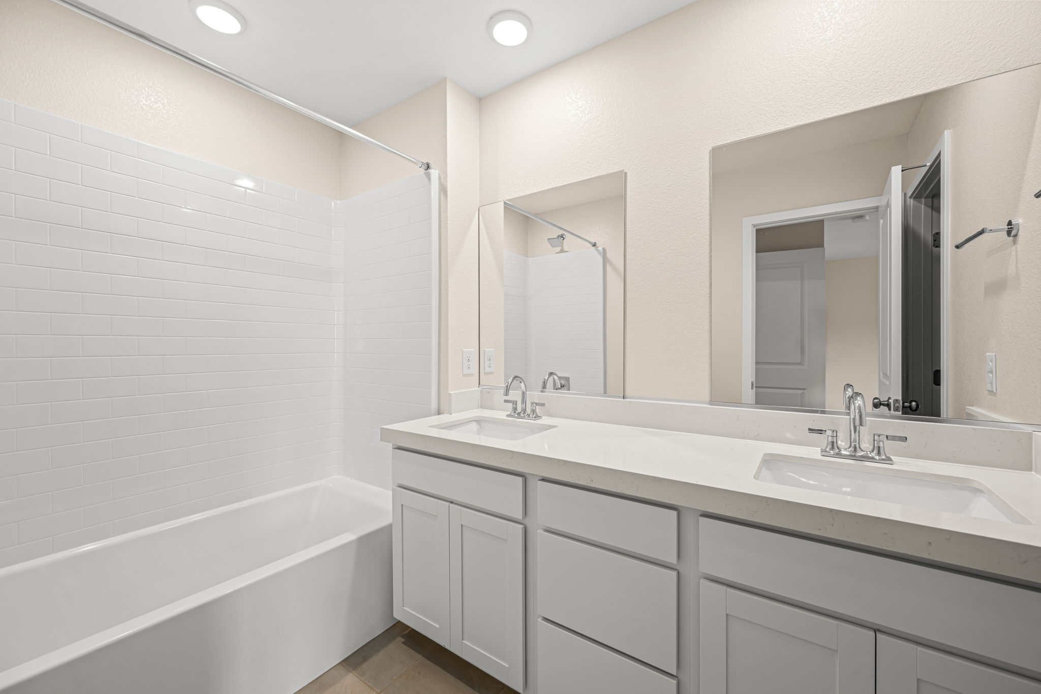 A bathroom with a tub sink and mirror.