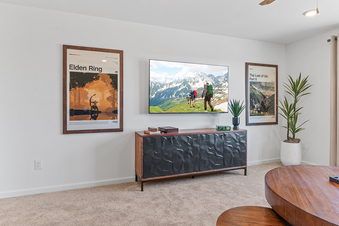 A room with a wall of paintings.