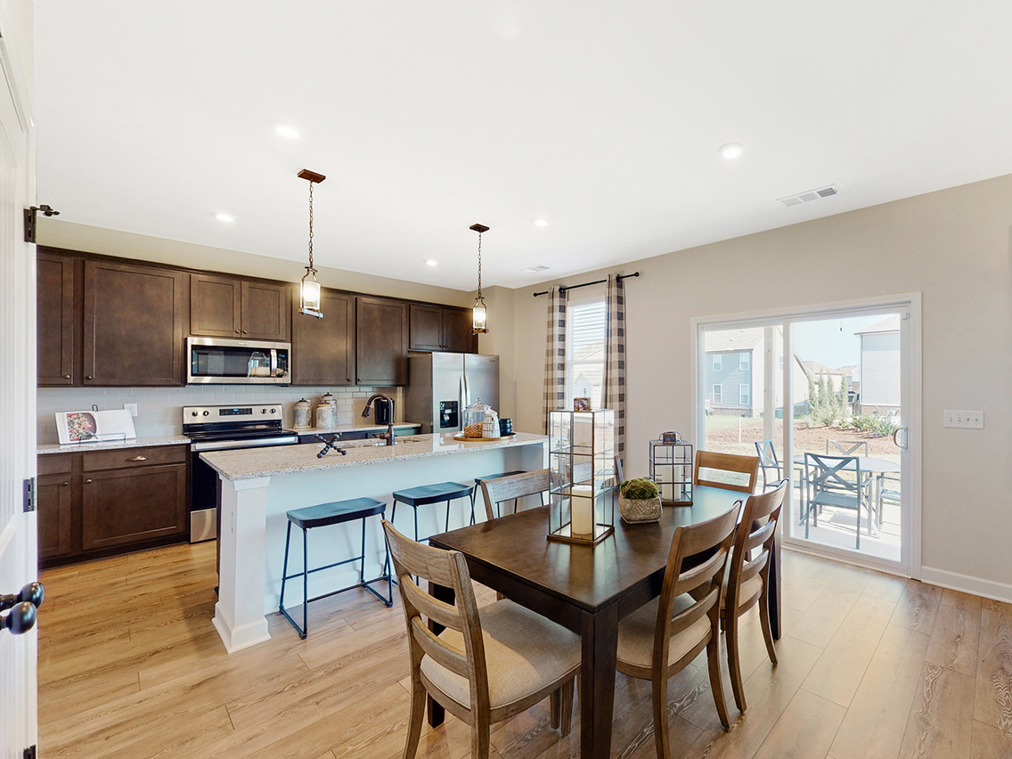 A kitchen with a dining table and a large window.