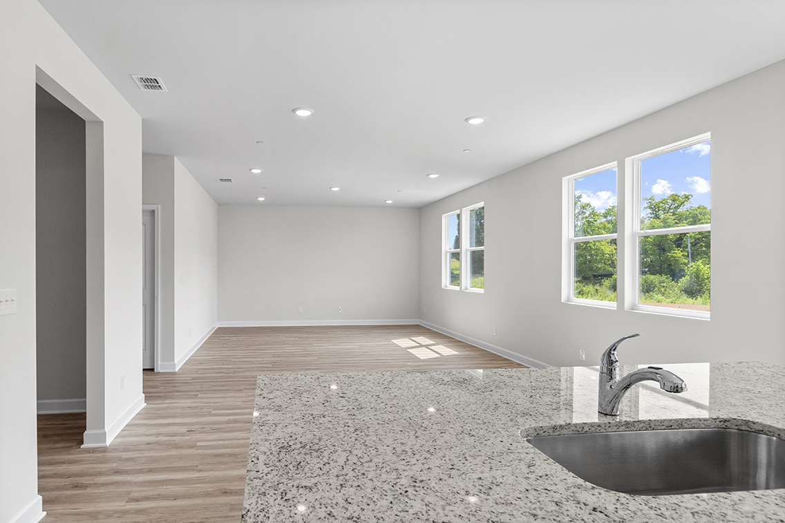 A large empty room with a sink and a large window.