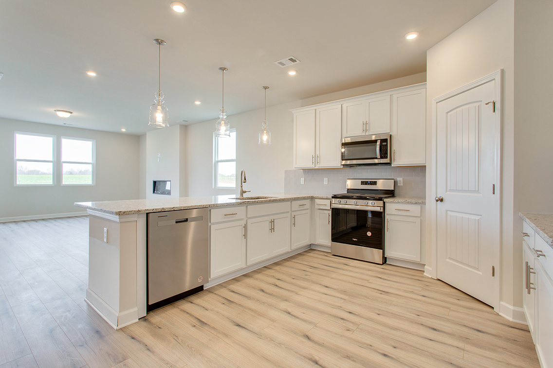 A kitchen with white cabinets.