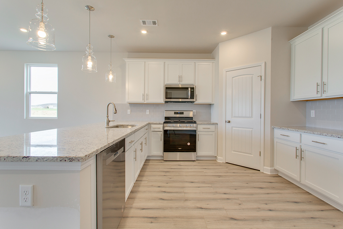 A kitchen with white cabinets.