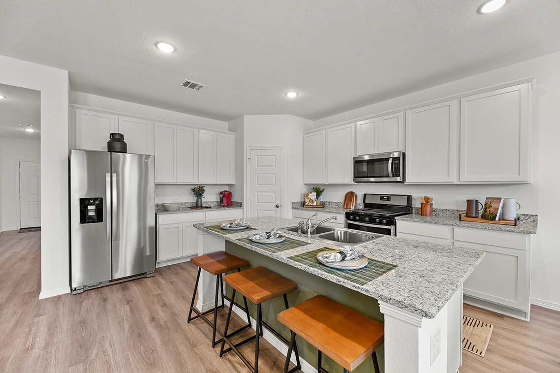 A kitchen with white cabinets.