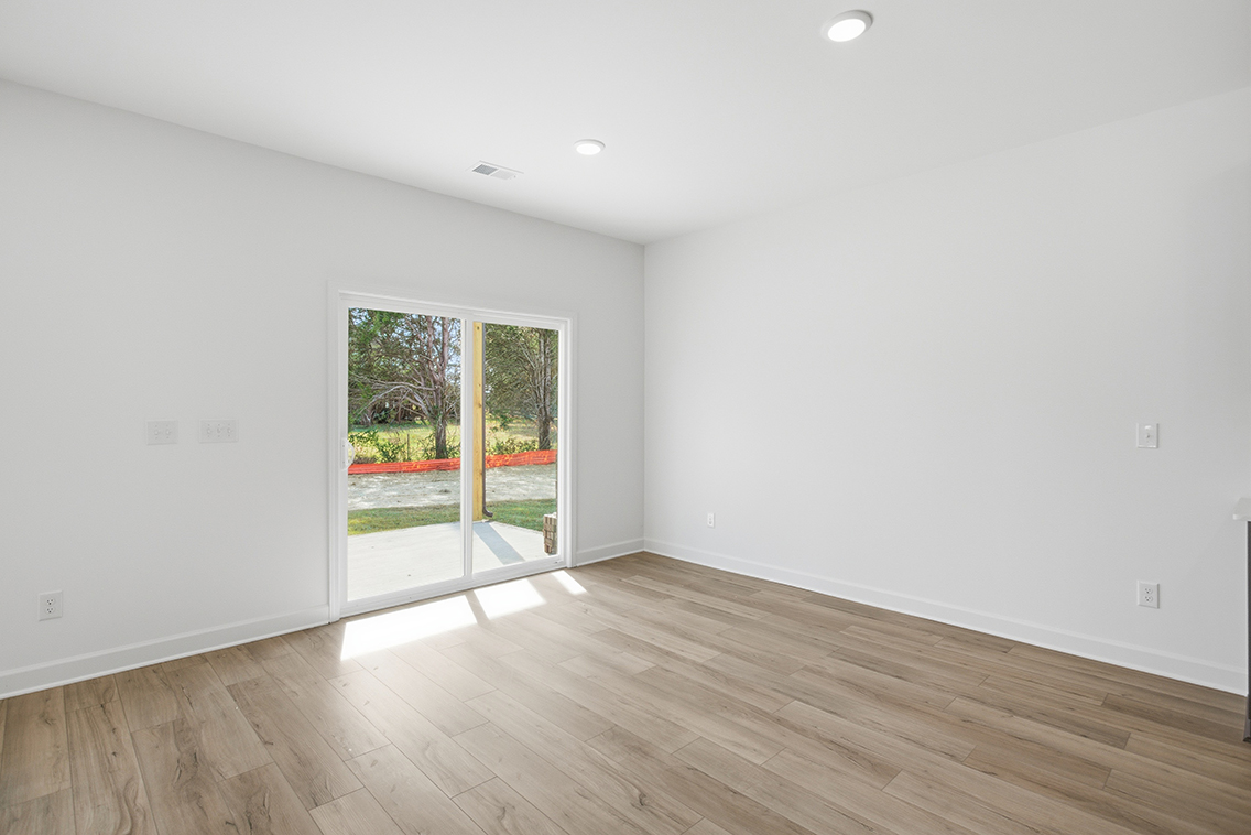 A room with a wood floor and a wood floor with a door.
