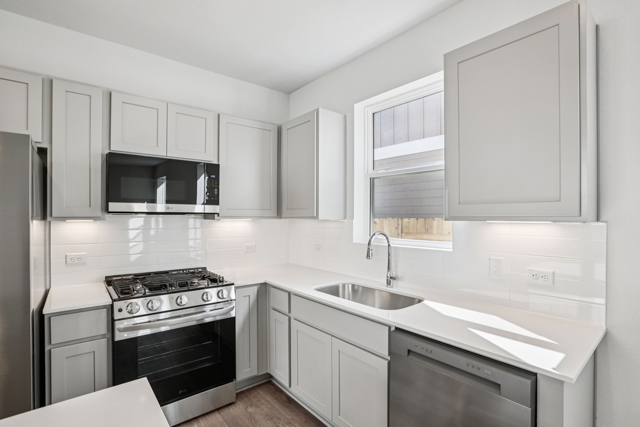 A kitchen with white cabinets.
