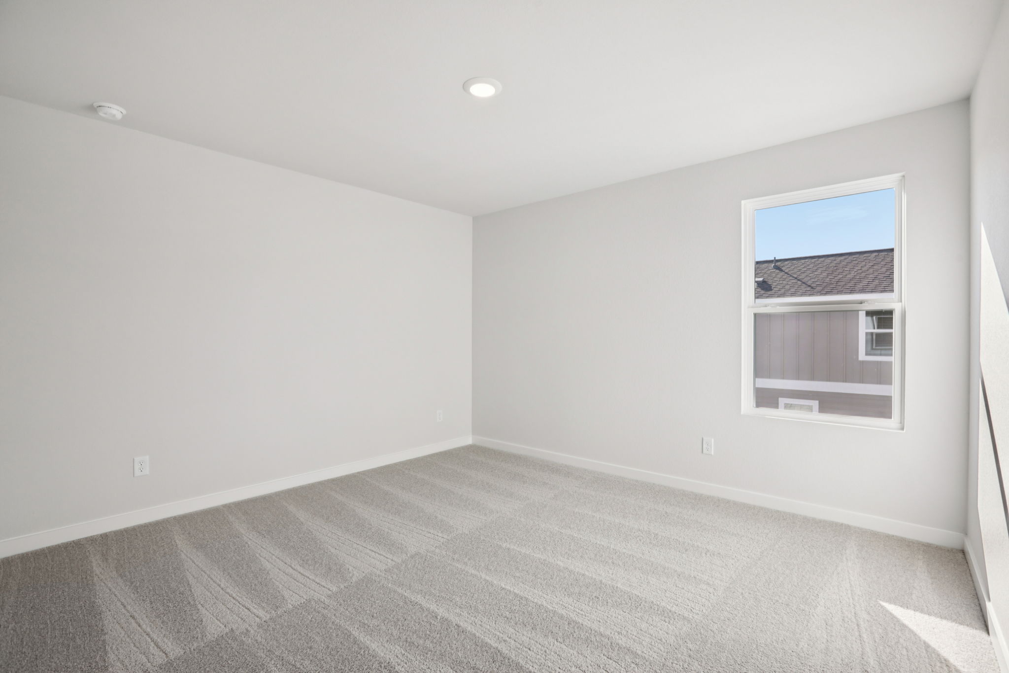 A room with a carpet and a window.