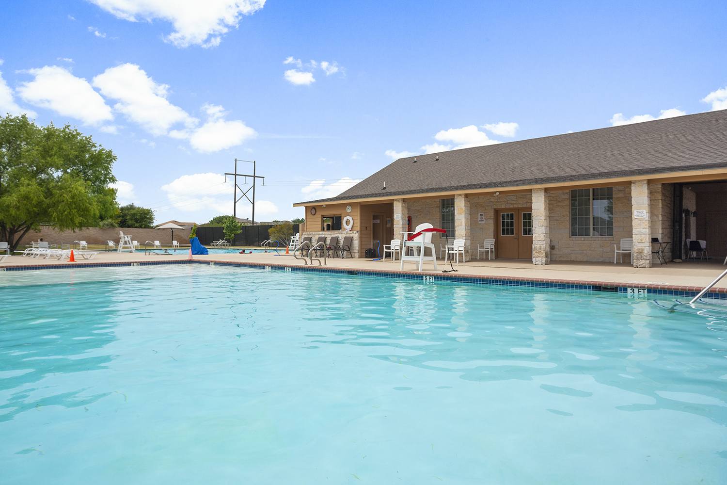 A swimming pool with a house in the background.