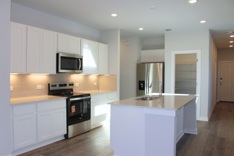 A kitchen with white cabinets.