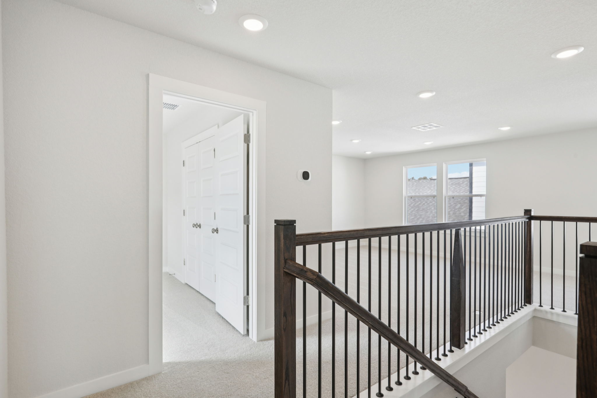 A white room with a black railing.