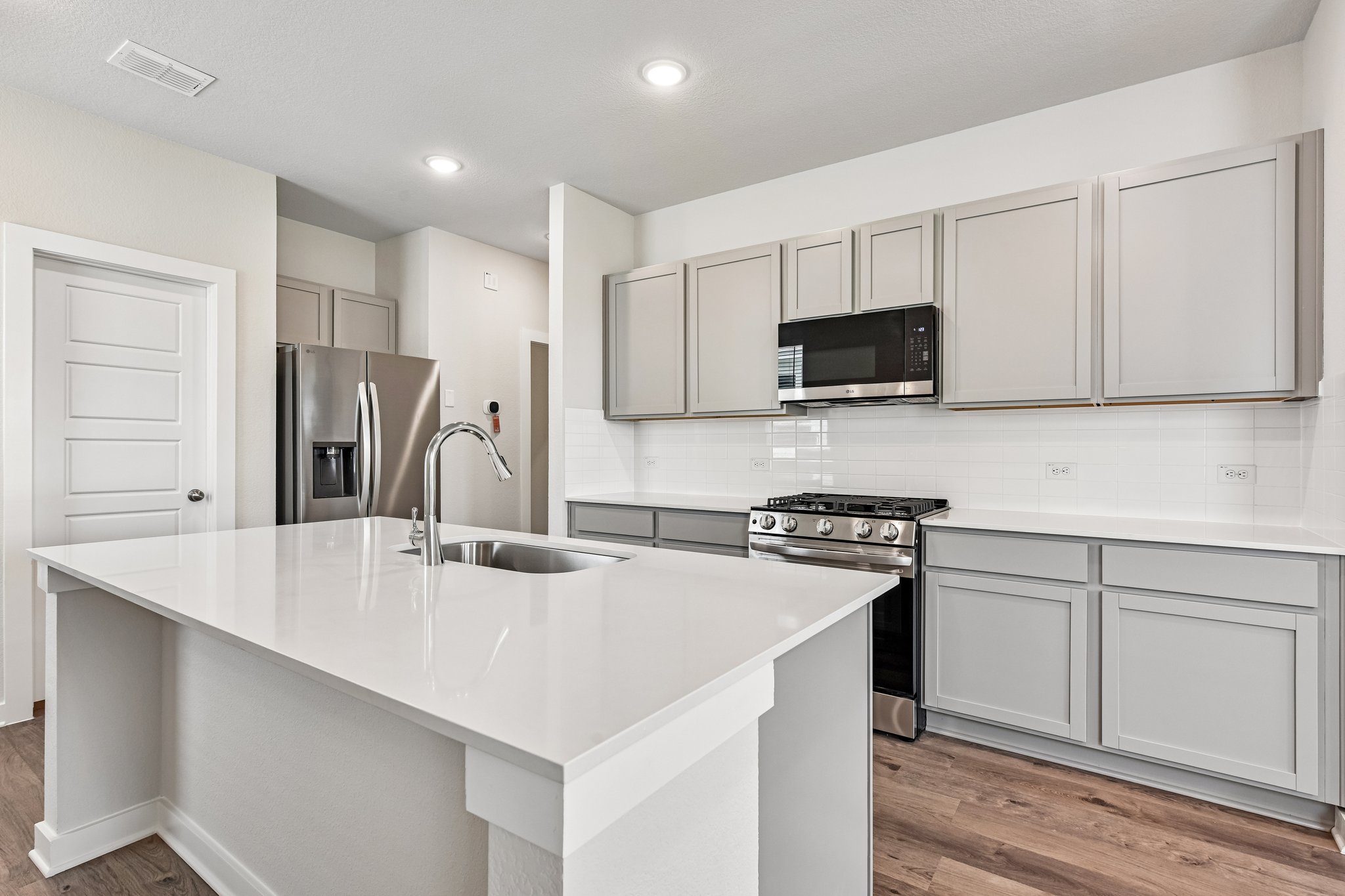 A kitchen with white cabinets.