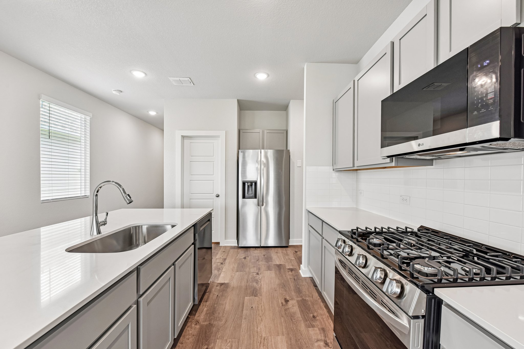 A kitchen with white cabinets.